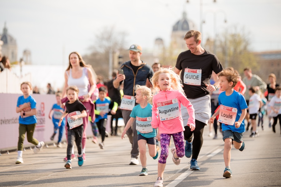 Kinder laufen am Start los. Am Rand jubeln Leute